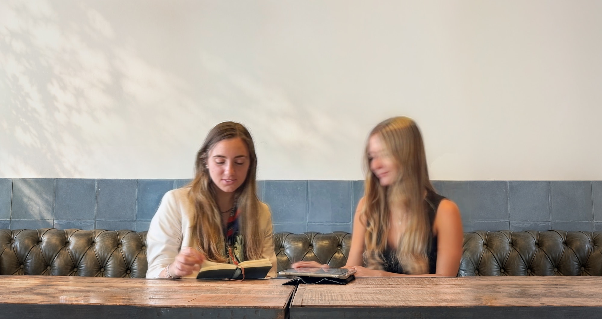 Catalina and Pilar, partners at cup arq, working at a wooden table.